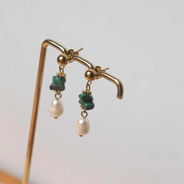 des boucles d'oreilles upcyclées composées d'une perles d'eau douce naturelle et de petites pierres turquoises de seconde main sur un portant