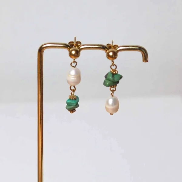 Des boucles d'oreilles composées de turquoises et perles d'eau naturelles de seconde main sur un portant
