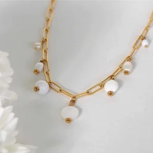 un collier upcyclé composé de sept perles blanches montées en breloques sur une chaîne en acier inoxydable mailles trombones dorée