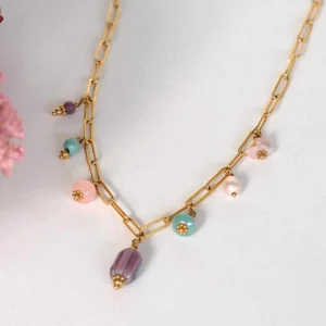 un collier upcyclé composé de sept perles de seconde main dans les tons pastels montées en breloques sur une chaîne en acier inoxydable mailles trombones dorée