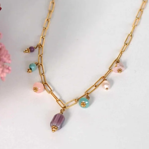 un collier upcyclé composé de sept perles de seconde main dans les tons pastels montées en breloques sur une chaîne en acier inoxydable mailles trombones dorée