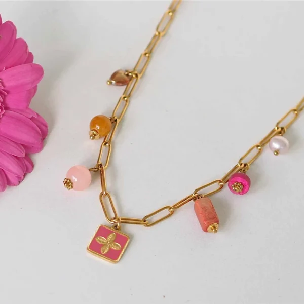 un collier upcyclé composé de perles de seconde main dans les tons roses et oranges montées en breloques sur une chaîne en acier inoxydable mailles trombones dorée