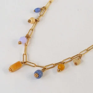 un collier upcyclé composé de perles orange et mauve de seconde main montées en breloques sur une chaîne en acier inoxydable mailles trombones dorée