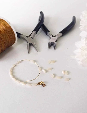 un bracelet cassé prêt à être réparé grâce à des pinces à bijoux