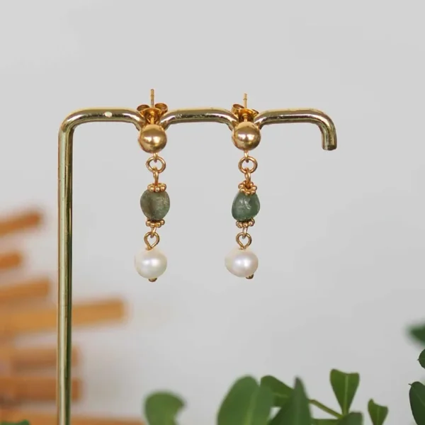 Des boucles d'oreilles upcyclées avec des perles naturelles de seconde main sur un portant