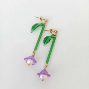 boucles d'oreilles upcyclées longues en forme de fleurs à plat sur fond blanc
