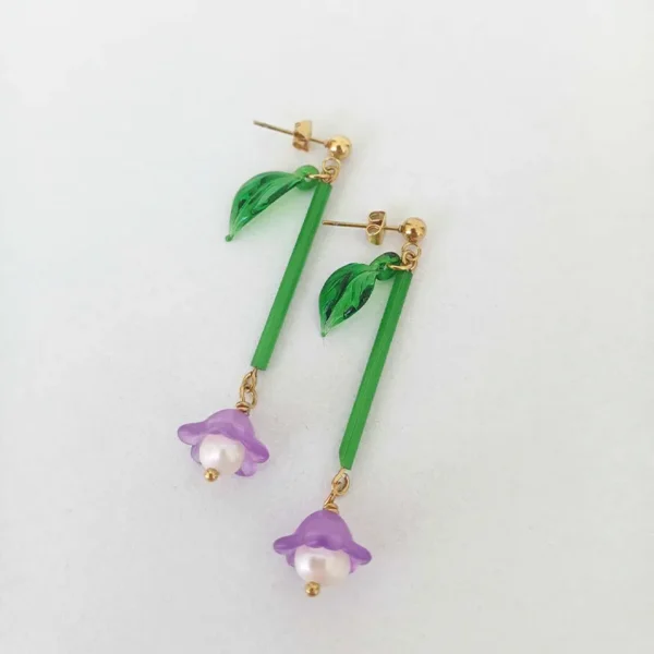 boucles d'oreilles upcyclées longues en forme de fleurs à plat sur fond blanc