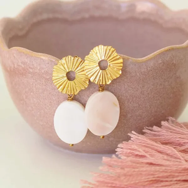 paire de boucles d'oreilles upcyclées en nacre blanche sur le bord d'un bol rose