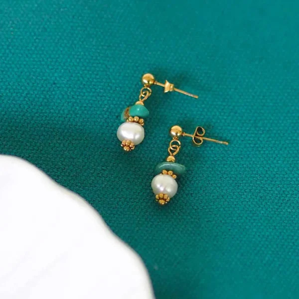Boucles d'oreilles upcyclées réalisées à partir de perles naturelles sur fond turquoise