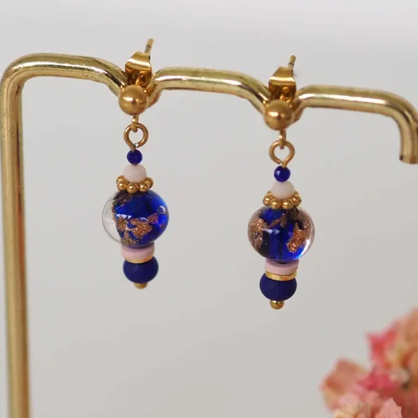 Boucles d'oreilles bleues nuit et roses pâles sur un portant