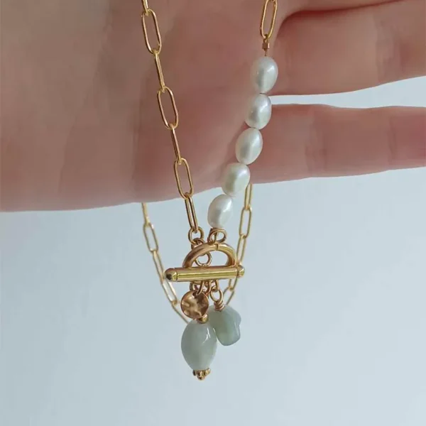 Une main qui tient un collier upcyclé en perles et pierres de seconde amin