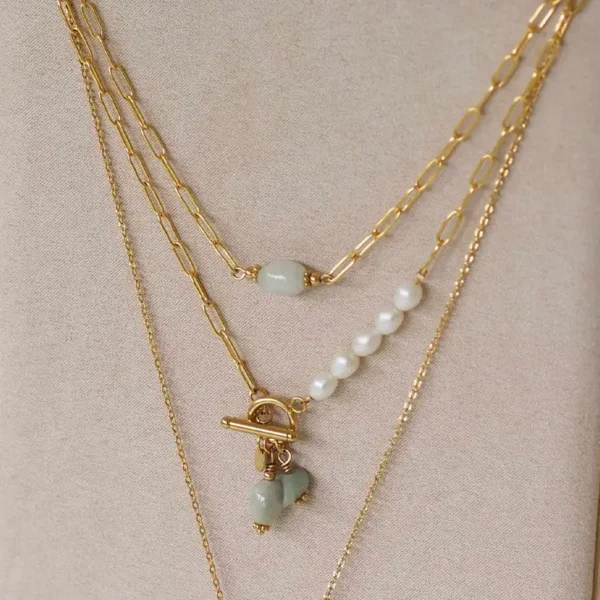 deux colliers upcyclés accrochés sur un présentoir à bijoux